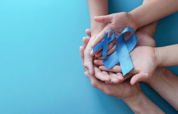 A group of hands holding two blue awareness ribbons