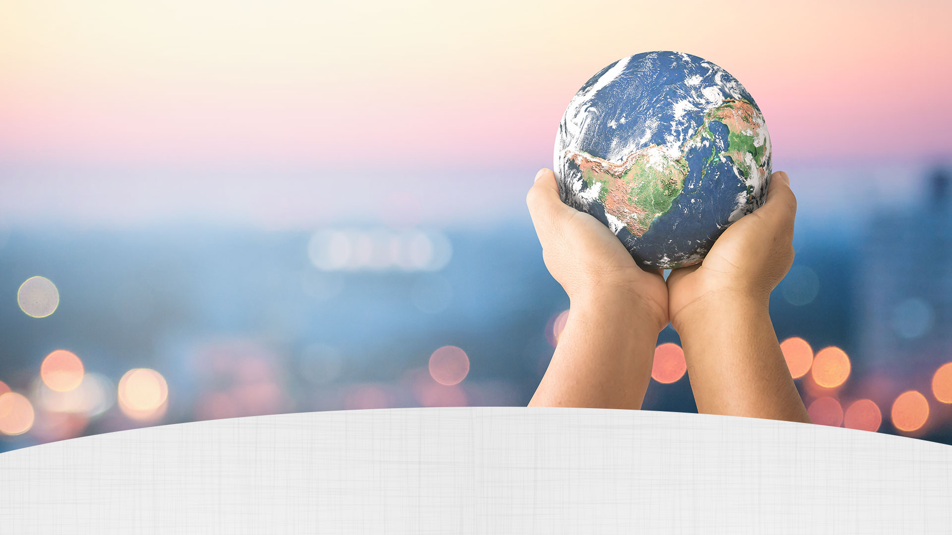 A pair of hands holding a model of the Earth