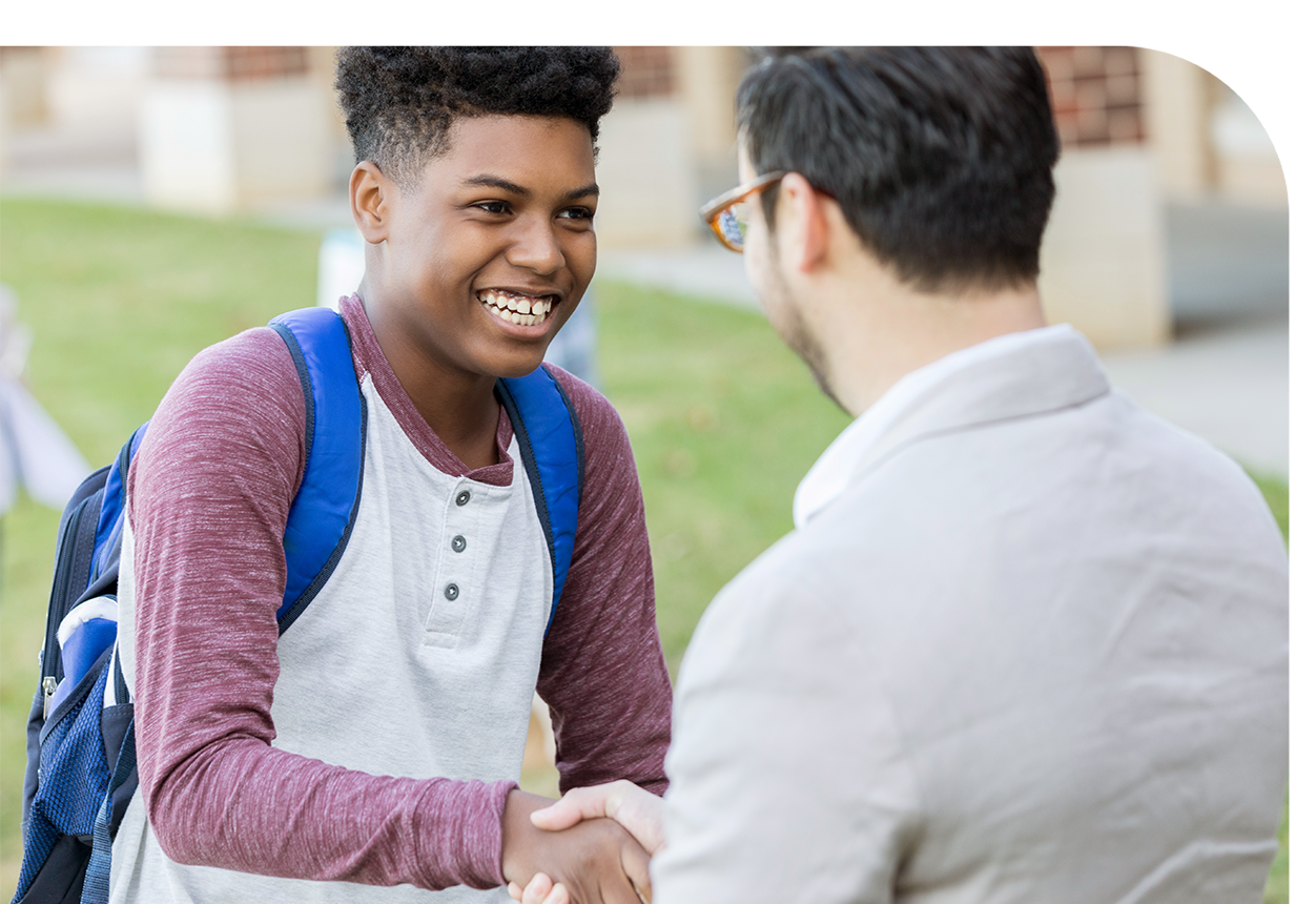 A young man shaking hands with a teacher